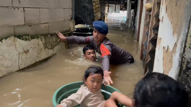 Gunakan Ember Besar, Personel Brimob Evakuasi Balita Korban Banjir di Kampung Melayu Jakarta Timur